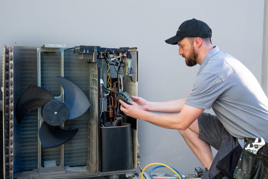 Beattie Air employee servicing Mitsubishi HVAC heat pump in Christchurch